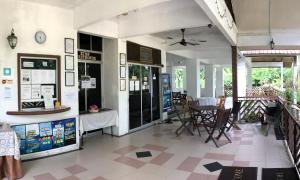 a restaurant with a table and chairs in a room at RTMS Guesthouse Semporna in Semporna
