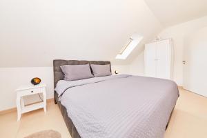 ein weißes Schlafzimmer mit einem Bett und einem Tisch in der Unterkunft Ferienwohnung Bella Vista in Bernkastel-Kues