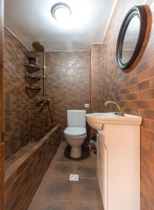 een badkamer met een toilet, een wastafel en een douche bij Guest House MK in Gori