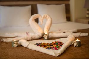 a bed with two towel swans and a couple of candles at Guest House MK in Gori