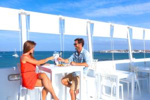 a man and woman sitting at a table on a boat at AVANTI Lifestyle Hotel - Only Adults in Corralejo