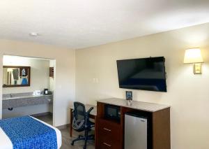 a hotel room with a bed and a flat screen tv at Travelodge by Wyndham Cedar City in Cedar City