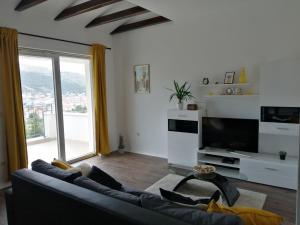 a living room with a couch and a large window at Apartmani Luka in Grebaštica