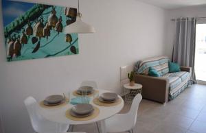 a living room with a table and chairs and a couch at APARTAMENTO MAGNIFIK in Corralejo