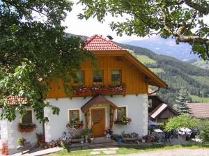 a house in the mountains with flowers at Ferienhaus Pirker in Eisentratten