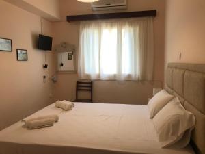 een slaapkamer met een groot bed en 2 handdoeken bij Natalia Studios in Póros