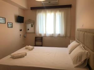 a bedroom with a large bed with two towels on it at Natalia Studios in Poros