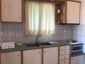 a kitchen with a sink and a window at Natalia Studios in Poros