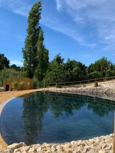 a large pool of water with a fence and trees at Quinta do Meco - Beach & Nature in Aldeia do Meco