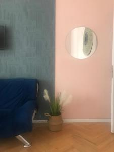 a living room with a blue couch and a plant at Guest House Story in Tbilisi City