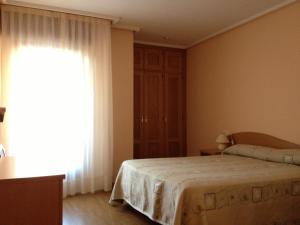 A bed or beds in a room at Apartamentos Turisticos Puerta de León