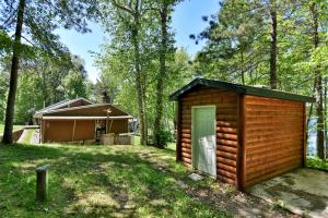 a small cabin in the woods with a house at Birch Bark Lodge Condo in Hayward