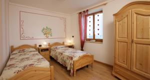 una camera da letto con due letti e una finestra di Villa Gardenia Molveno a Molveno