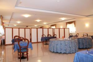 a banquet hall with tables and chairs with blue tablecloths at Hotel Ristorante Mariano in Stigliano