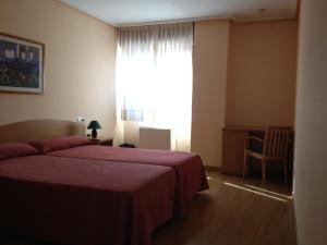 A bed or beds in a room at Apartamentos Turisticos Puerta de León