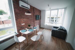 een woonkamer met een bakstenen muur en een tafel en stoelen bij Kostjukowski Apartments Shevchenka 60 in Lviv