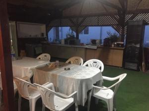 a dining room with two tables and white chairs at Casa Cleopatra 2 MAI in 2 Mai