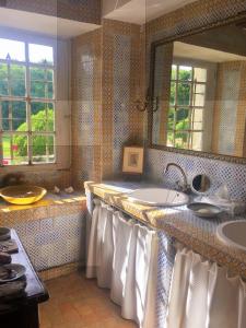 uma casa de banho com 2 lavatórios e um espelho em Manoir de la Rémonière em Azay-le-Rideau