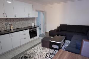 a kitchen and a living room with a couch at Kings Apartment 4 in Kolgecaj