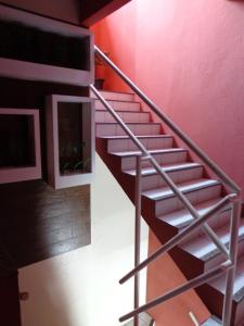 una escalera de metal en una habitación con una pared roja en Pousada Dom Kilmer, en Fortaleza