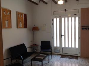 a living room with two chairs and a sliding door at Casa Rural Josep in Ador