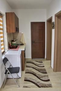 a kitchen with a table and a chair and a door at Bridge Apartment in Kratovo