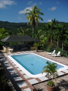 a swimming pool with a gazebo and palm trees at Tamarind Great House in Oracabessa