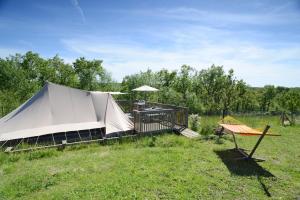 a large white tent in a field with a table at Ingerichte tenten Domaine les Gonies in Mauroux