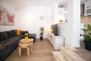 ein Wohnzimmer mit Sofa und Tisch in der Unterkunft Apartman Villa Katrina in Mošćenička Draga