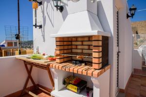 a outdoor kitchen with a brick oven on a balcony at L'Atalaya D'or in Oropesa del Mar