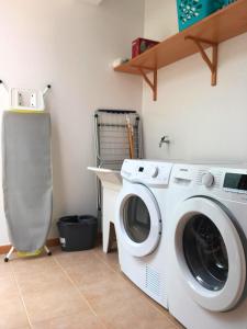 une buanderie avec un lave-linge et un bureau dans l'établissement Ponte House, à Porto Moniz