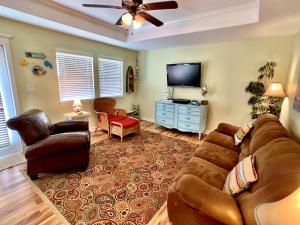 a living room with a couch and a flat screen tv at Mi Casa Del Mar Home in Caplen