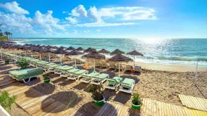 plaża z leżakami i parasolami oraz ocean w obiekcie Jupiter Sea Horse Vacations w mieście Benalmádena