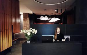 une femme assise sur un bureau avec un ordinateur portable dans l'établissement Fauno Urban Resort, à Rome