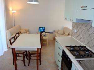a kitchen and living room with a table and a laptop at Alba Blu in Santa Caterina Dello Ionio Marina