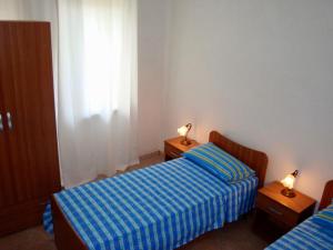 a bedroom with two beds and two lamps on tables at Alba Blu in Santa Caterina Dello Ionio Marina