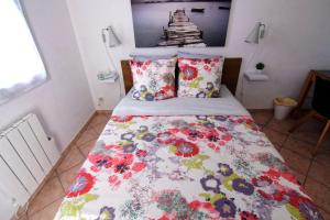 a bed with a floral comforter in a bedroom at Villa Louanne in Pertuis
