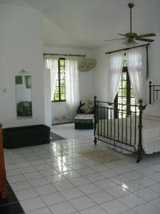 a bedroom with a bed and two windows at Tamarind Great House in Oracabessa