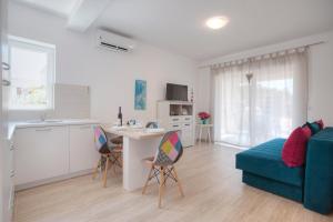 eine Küche und ein Wohnzimmer mit einem blauen Sofa in der Unterkunft Guest House Djonovic in Petrovac na Moru