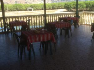 un restaurante con mesas y sillas y un balcón en H and H Guesthouse, en Velipojë