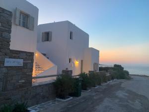 ein weißes Gebäude mit dem Ozean im Hintergrund in der Unterkunft Sea & Sun Paros in Naoussa