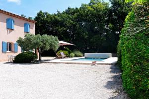a house and a swimming pool in a yard at Villa Louanne in Pertuis