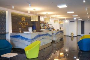 a restaurant with a counter with yellow and blue chairs at Nautilus Hotel in Giardini Naxos