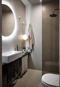 a bathroom with a sink and a toilet and a mirror at Apartamenty DECK Jurata in Jurata
