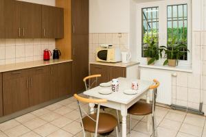 a kitchen with a table with chairs and a microwave at BP Hostel Gdynia in Gdynia