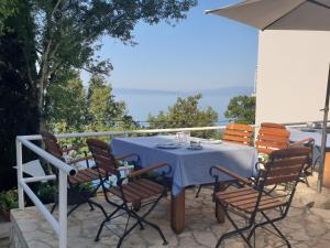 een tafel en stoelen op een patio met uitzicht op de oceaan bij Rooms Villa Lucija in Kraljevica