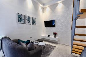 a living room with a couch and a tv on a wall at VenaRi apartments, Rijeka in Rijeka