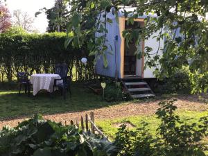 a small house with a table and chairs in a yard at Bauwagen Villa Frederik in Radebeul