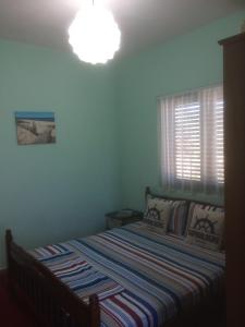 a bedroom with a bed and a light on the ceiling at H and H Guesthouse in Velipojë