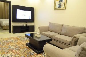 uma sala de estar com um sofá e uma televisão de ecrã plano em مشارف الفخامة أبها em Abha